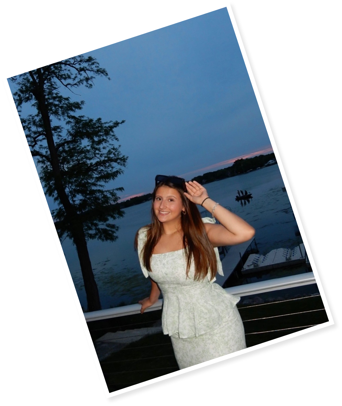 Woman posing by a lake at sunset.